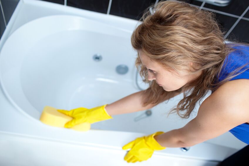 Woman cleaning bathroom with eraser products