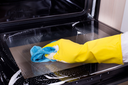 Cleaning Oven with blue microfiber cloth 