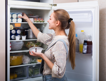 woman cleaning out fridge