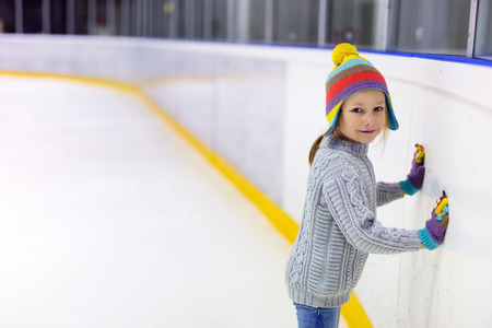 Girl leaning against skating arena boards