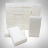 A stack of melamine foam eraser sponges with two eraser sponges in front to show length. Sponge Outlet bulk eraser sponges.